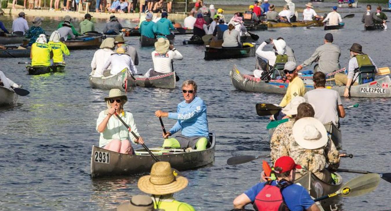 Spring Lake in San Marcos, above, is filled with boats before the 2018 race begins. At right, the Miller Creek Racing Team jumps into the water after successfully passing its boat down the spillway of the Zedler Mill dam in Luling.